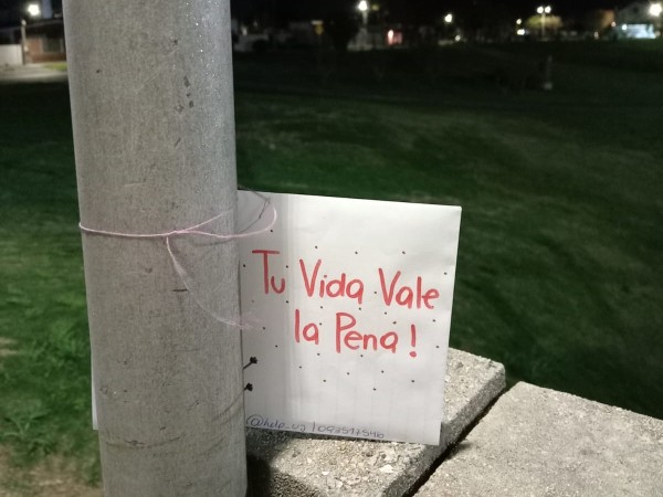 Un grupo de voluntarios deposita cartas en espacios públicos con mensajes positivos